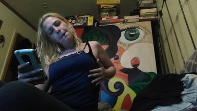 Une blonde chaude fume des cigarettes au clou de girofle, joue au téléphone et joue avec ses seins