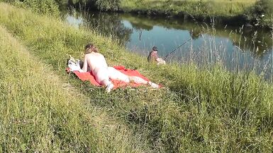 Wild beach. Sexy MILF Platinum naked sunbathing on river bank, random fisherman guy watches. Naked in public. Nude beach - 10 image