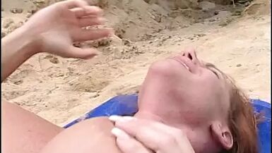 Gorgeous red head lays on the beach and gets her pussy licked - 1 image