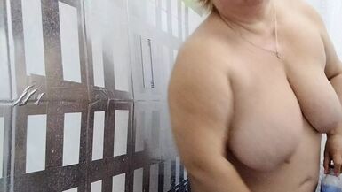 Une belle-mère nue avec de gros seins et un gros cul prend une douche