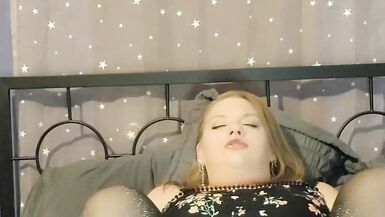 Une grosse fille sexy joue avec sa chatte rasée et mouillée dans une robe et des collants transparents. - 9 image