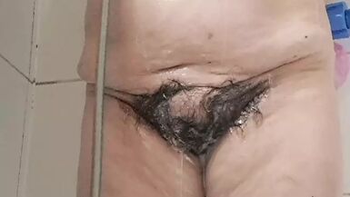 Mature milf bathing her tits and hairy pussy gets excited by the water - 1 image