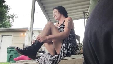 Une femme brune enfile des bottes de combat avec une robe